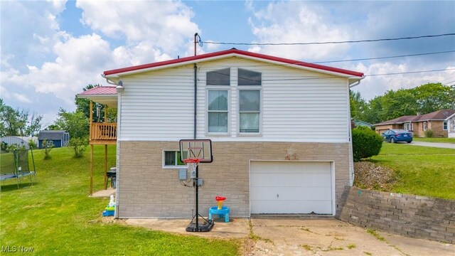 208 Jefferson Blvd, Mingo Junction, OH 43938 - view of property exterior featuring a trampoline, concrete driveway, a lawn, and a garage