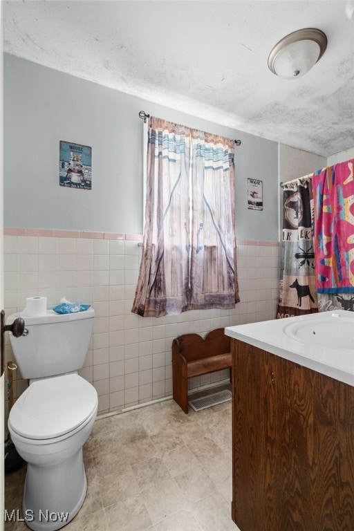 415 N Columbus St, Crestline, OH 44827 - bathroom featuring tile walls, vanity, and a wainscoted wall