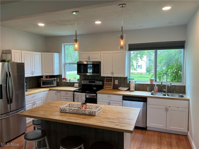45055 N Ridge Rd, Amherst, OH 44001 - kitchen featuring appliances with stainless steel finishes, wood counters, a breakfast bar area, white cabinetry, and recessed lighting