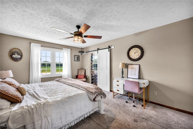 12208 State Route 113, Wakeman, OH 44889 - bedroom featuring carpet, a barn door, a ceiling fan, a textured ceiling, and a walk in closet