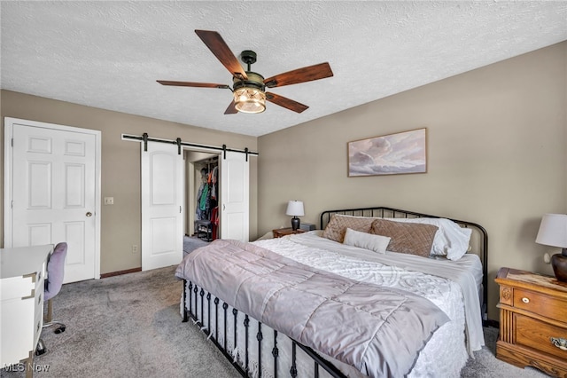 12208 State Route 113, Wakeman, OH 44889 - carpeted bedroom featuring a barn door, a textured ceiling, ceiling fan, and a spacious closet