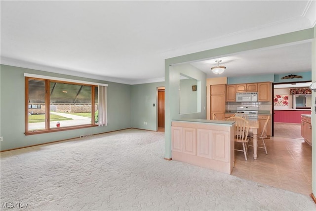 4899 Autumn Ln, Brooklyn, OH 44144 - kitchen with white microwave, crown molding, open floor plan, and a peninsula