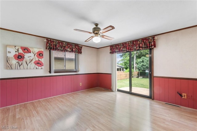 4899 Autumn Ln, Brooklyn, OH 44144 - empty room featuring wood finished floors, healthy amount of natural light, a wainscoted wall, ceiling fan, and ornamental molding