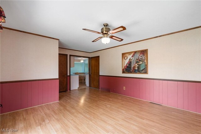 4899 Autumn Ln, Brooklyn, OH 44144 - spare room with wood finished floors, ceiling fan, wainscoting, and ornamental molding