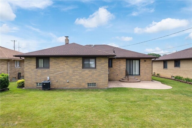 4899 Autumn Ln, Brooklyn, OH 44144 - back of house featuring a patio area, a yard, a chimney, brick siding, and roof with shingles