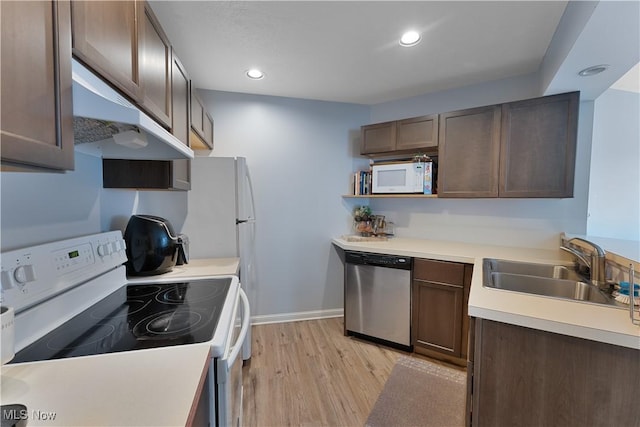 1173 Red Tail Hawk Ct Unit 4, Youngstown, OH 44512 - kitchen with white appliances, light wood finished floors, dark brown cabinetry, under cabinet range hood, and light countertops