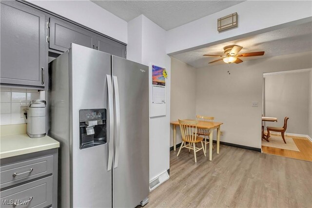 4090 Ridgeview Rd, Cleveland, OH 44144 - kitchen with stainless steel fridge, light wood-type flooring, gray cabinetry, and a textured ceiling