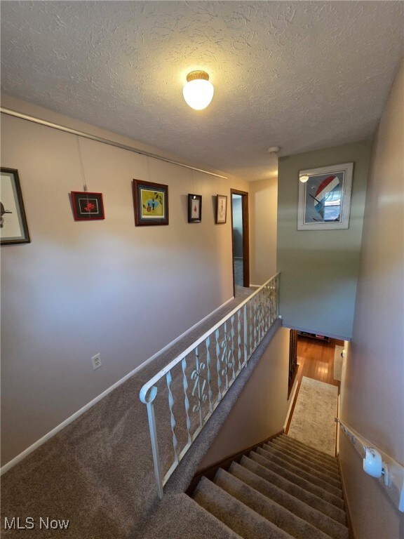 4090 Ridgeview Rd, Cleveland, OH 44144 - staircase with a textured ceiling and wood finished floors