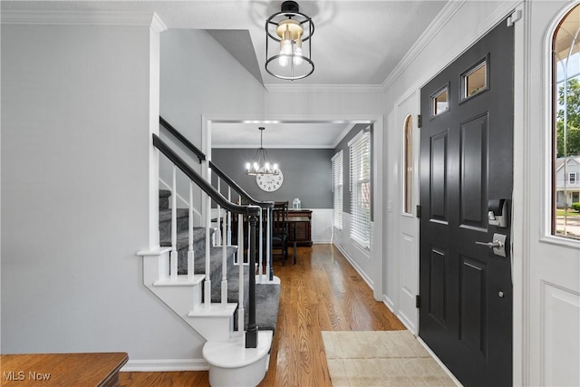 3049 Deercrest Path, Stow, OH 44224 - entrance foyer featuring a chandelier, stairway, wood finished floors, plenty of natural light, and crown molding