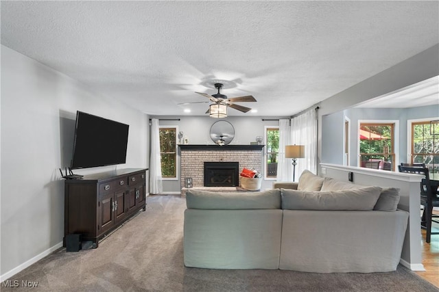 3049 Deercrest Path, Stow, OH 44224 - living area with a ceiling fan, a fireplace, a textured ceiling, and light colored carpet