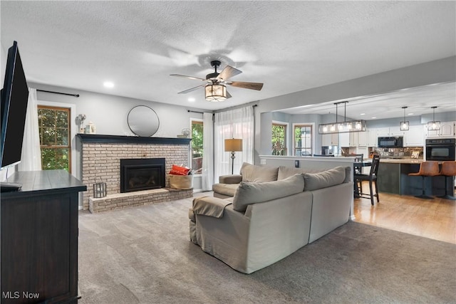 3049 Deercrest Path, Stow, OH 44224 - living area featuring light carpet, ceiling fan, a textured ceiling, a brick fireplace, and recessed lighting