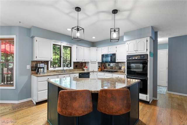 3049 Deercrest Path, Stow, OH 44224 - kitchen with black appliances, light stone counters, white cabinets, light wood finished floors, and backsplash