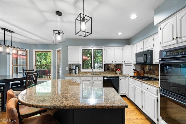 3049 Deercrest Path, Stow, OH 44224 - kitchen with black appliances, plenty of natural light, light stone counters, light wood-style floors, and recessed lighting