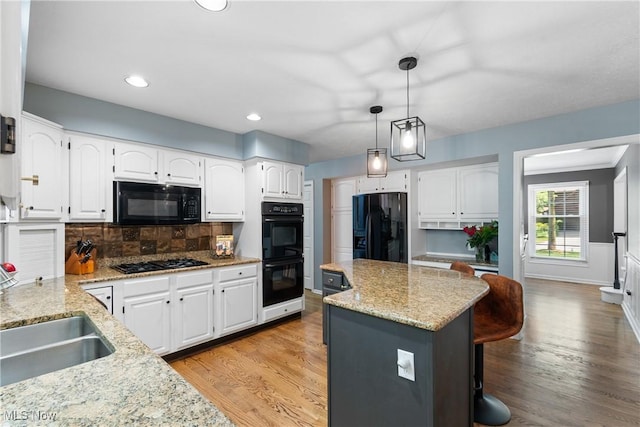 3049 Deercrest Path, Stow, OH 44224 - kitchen featuring black appliances, light stone counters, a center island, tasteful backsplash, and white cabinetry