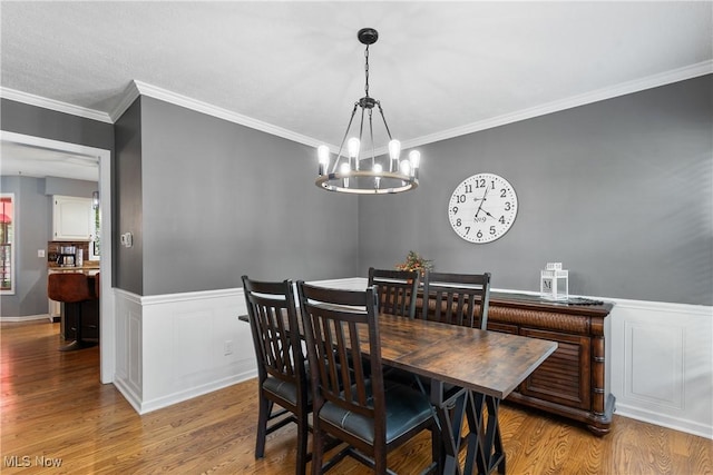 3049 Deercrest Path, Stow, OH 44224 - dining area featuring wood finished floors, a chandelier, ornamental molding, a wainscoted wall, and a decorative wall