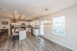 105 Vesper Cir, Lodi, OH 44254 - kitchen with white cabinetry, a kitchen island, pendant lighting, stainless steel fridge with ice dispenser, and a kitchen breakfast bar