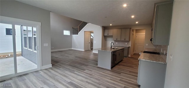 9125 Ledge View Ter, Broadview Heights, OH 44147 - kitchen with light wood-style flooring, light stone counters, a center island with sink, recessed lighting, and gray cabinets