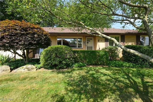 731 Hemlock St NW, Massillon, OH 44647 - view of front of home with brick siding and a front lawn