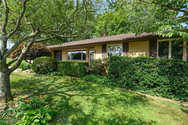731 Hemlock St NW, Massillon, OH 44647 - view of front of house featuring brick siding and a front yard