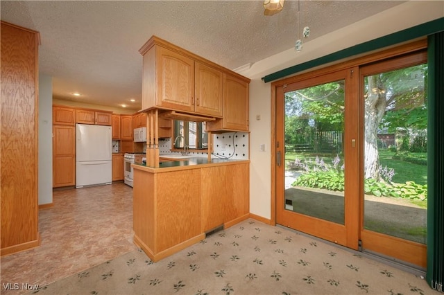 731 Hemlock St NW, Massillon, OH 44647 - kitchen featuring white appliances, a peninsula, plenty of natural light, light floors, and recessed lighting
