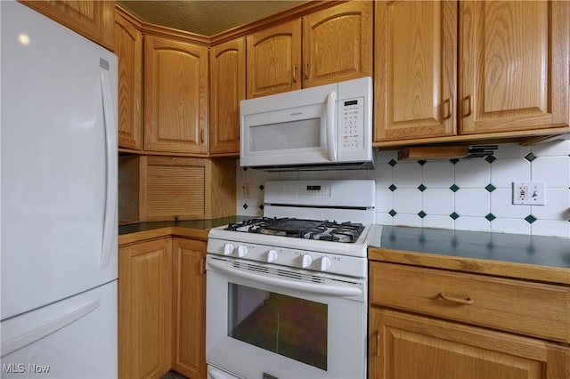 731 Hemlock St NW, Massillon, OH 44647 - kitchen with white appliances, tasteful backsplash, dark countertops, and brown cabinets