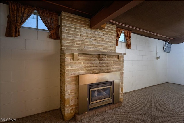 731 Hemlock St NW, Massillon, OH 44647 - unfurnished living room featuring concrete block wall, a glass covered fireplace, and carpet