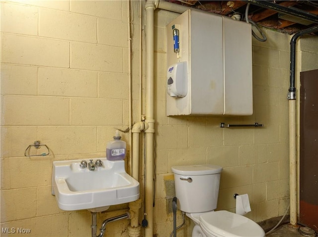 731 Hemlock St NW, Massillon, OH 44647 - bathroom featuring concrete block wall and a sink