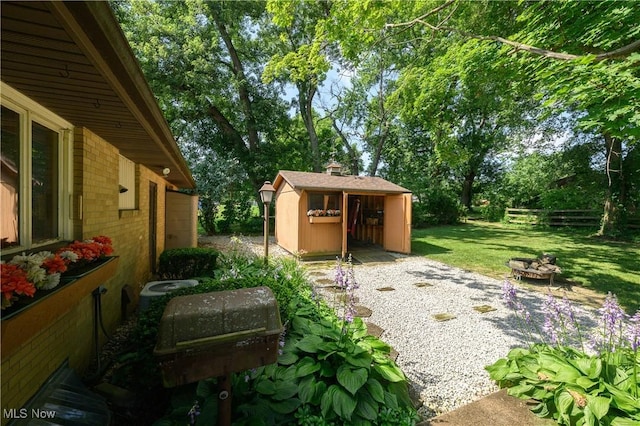 731 Hemlock St NW, Massillon, OH 44647 - view of grassy yard featuring a shed, a fire pit, and view of scattered trees