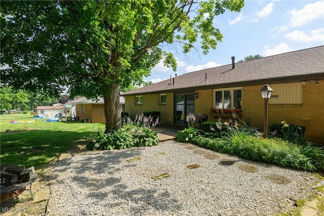 731 Hemlock St NW, Massillon, OH 44647 - rear view of property with a yard, brick siding, and a shingled roof