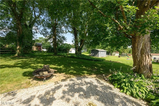731 Hemlock St NW, Massillon, OH 44647 - view of green lawn with a storage shed and a fire pit