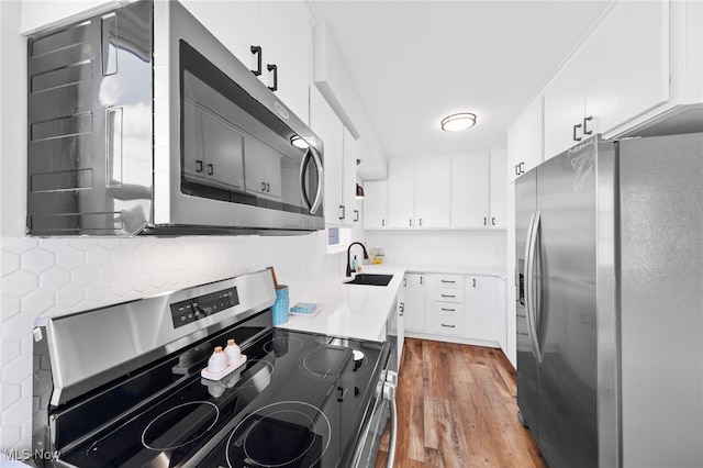 3763 Orchard St, Mogadore, OH 44260 - kitchen with appliances with stainless steel finishes, wood finished floors, white cabinets, light countertops, and tasteful backsplash