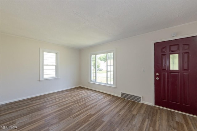 21304 Watson Rd, Maple Heights, OH 44137 - entryway with wood finished floors, ornamental molding, and a textured ceiling