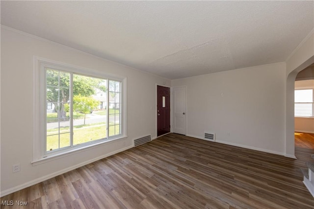 21304 Watson Rd, Maple Heights, OH 44137 - unfurnished living room with arched walkways, wood finished floors, a textured ceiling, and crown molding