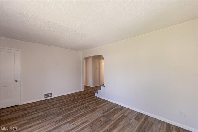 21304 Watson Rd, Maple Heights, OH 44137 - spare room with arched walkways, wood finished floors, and a textured ceiling