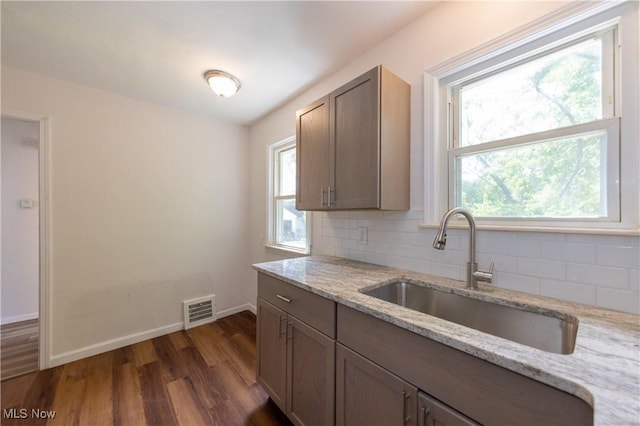 21304 Watson Rd, Maple Heights, OH 44137 - kitchen with dark wood-type flooring, decorative backsplash, and light stone countertops