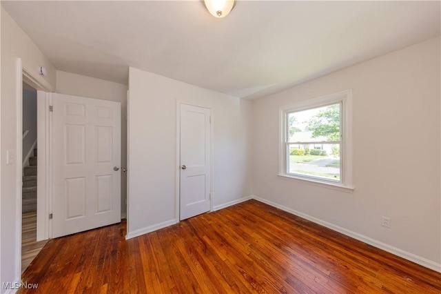 21304 Watson Rd, Maple Heights, OH 44137 - unfurnished bedroom with wood-type flooring and baseboards
