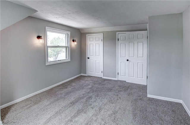 16005 Mendota Ave, Maple Heights, OH 44137 - unfurnished bedroom featuring carpet flooring, vaulted ceiling, and two closets