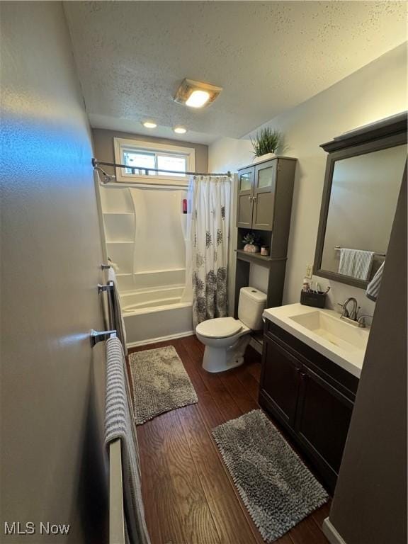 3868 Adams Ave, Shadyside, OH 43947 - bathroom with a textured ceiling, wood finished floors, vanity, and shower / bath combo with shower curtain