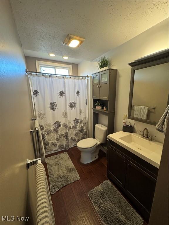 3868 Adams Ave, Shadyside, OH 43947 - bathroom with a textured ceiling, wood finished floors, vanity, and curtained shower