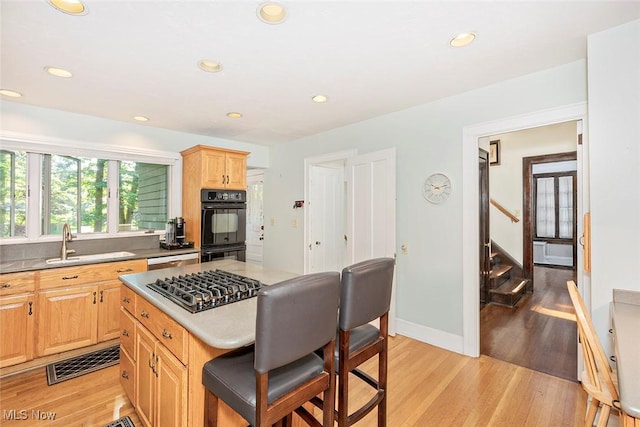 1539 Compton Rd, Cleveland Heights, OH 44118 - kitchen featuring stainless steel gas stovetop, light wood-type flooring, light brown cabinets, a kitchen breakfast bar, and recessed lighting