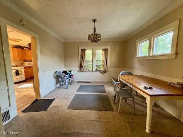 19510 Gardenview Dr, Maple Heights, OH 44137 - dining area with light carpet, a chandelier, ornamental molding, and wainscoting