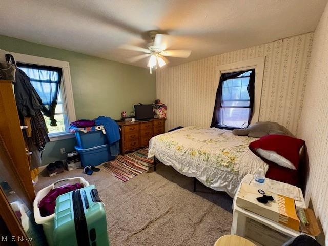19510 Gardenview Dr, Maple Heights, OH 44137 - bedroom with carpet floors, wallpapered walls, and a ceiling fan