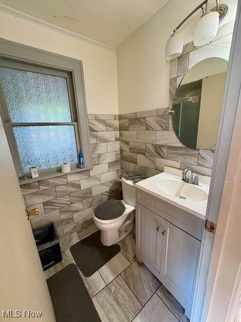 19510 Gardenview Dr, Maple Heights, OH 44137 - bathroom with tile walls, crown molding, and vanity