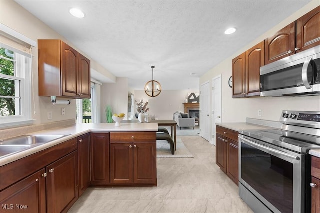 184 Creekledge Ln, Copley, OH 44321 - kitchen featuring appliances with stainless steel finishes, a fireplace, healthy amount of natural light, light countertops, and recessed lighting