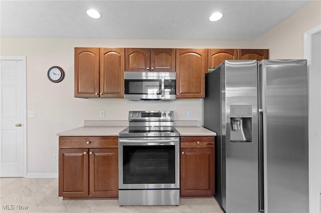 184 Creekledge Ln, Copley, OH 44321 - kitchen with stainless steel appliances, light countertops, brown cabinetry, and recessed lighting