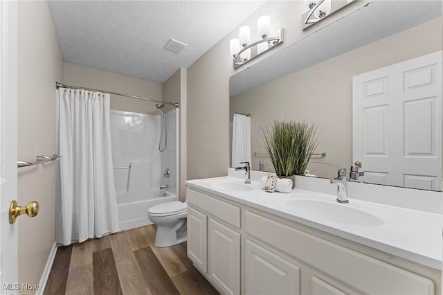 184 Creekledge Ln, Copley, OH 44321 - bathroom featuring wood finished floors, double vanity, shower / tub combo with curtain, and a textured ceiling