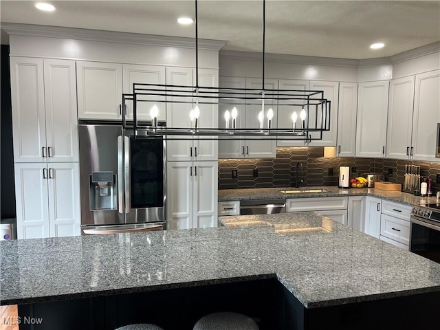 116 Ledgestone Ct, Berea, OH 44017 - kitchen with appliances with stainless steel finishes, a kitchen island, dark stone counters, white cabinetry, and decorative backsplash