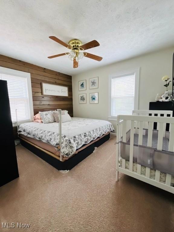 4575 Fishcreek Rd, Stow, OH 44224 - carpeted bedroom with multiple windows, a ceiling fan, a textured ceiling, and wood walls