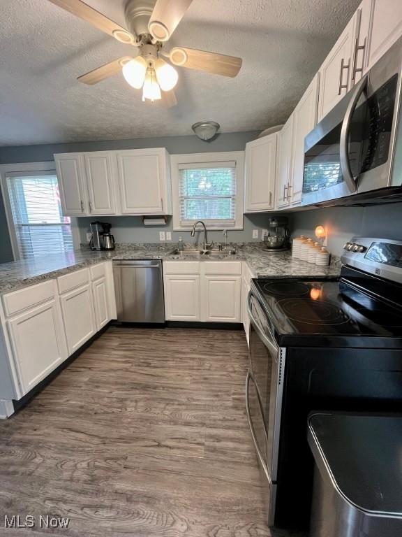 4575 Fishcreek Rd, Stow, OH 44224 - kitchen featuring appliances with stainless steel finishes, a textured ceiling, plenty of natural light, and white cabinets