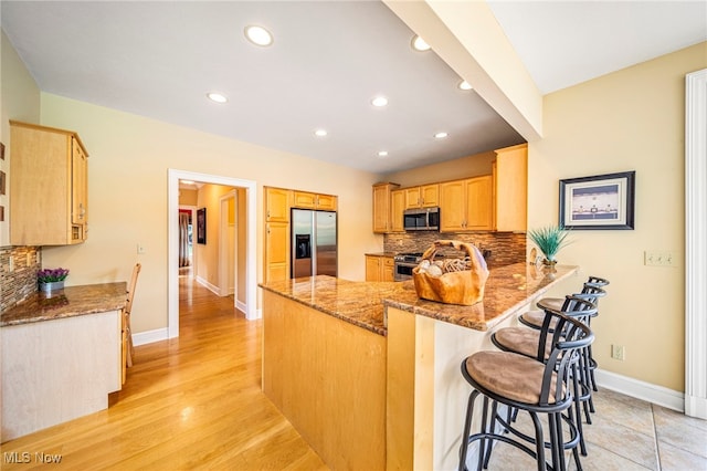 11275 Beechnut Ln, Chardon, OH 44024 - kitchen with stainless steel appliances, a peninsula, tasteful backsplash, stone counters, and recessed lighting